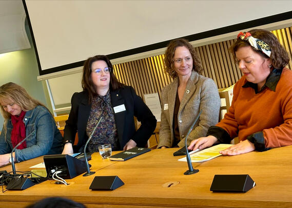 Tre kvinner sitter ved et bord.