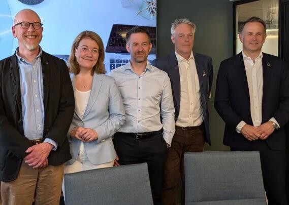 Fem voksne mennesker står ved siden av hverandre og ser mot fotografen.