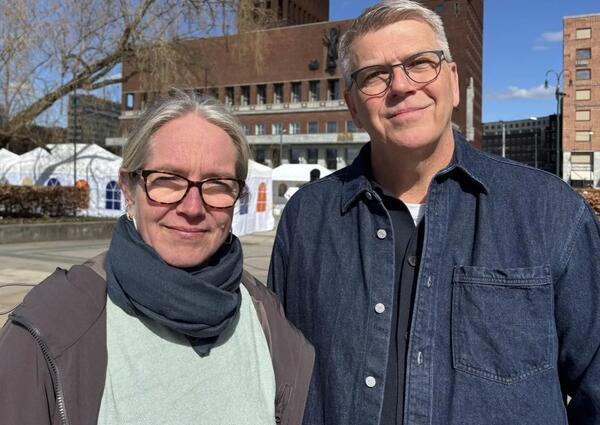 Kvinne med briller og mann med briller står ved siden av hverandre.