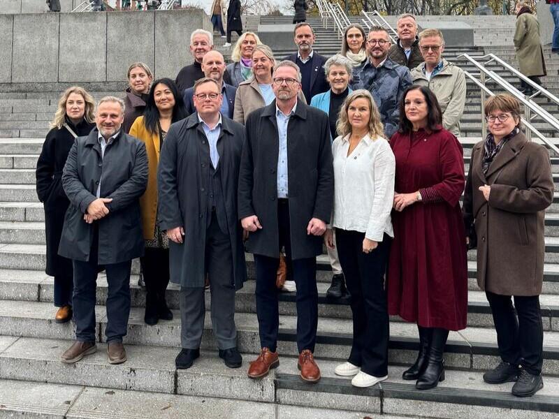 En gruppe mennesker står oppstilt i en trapp.