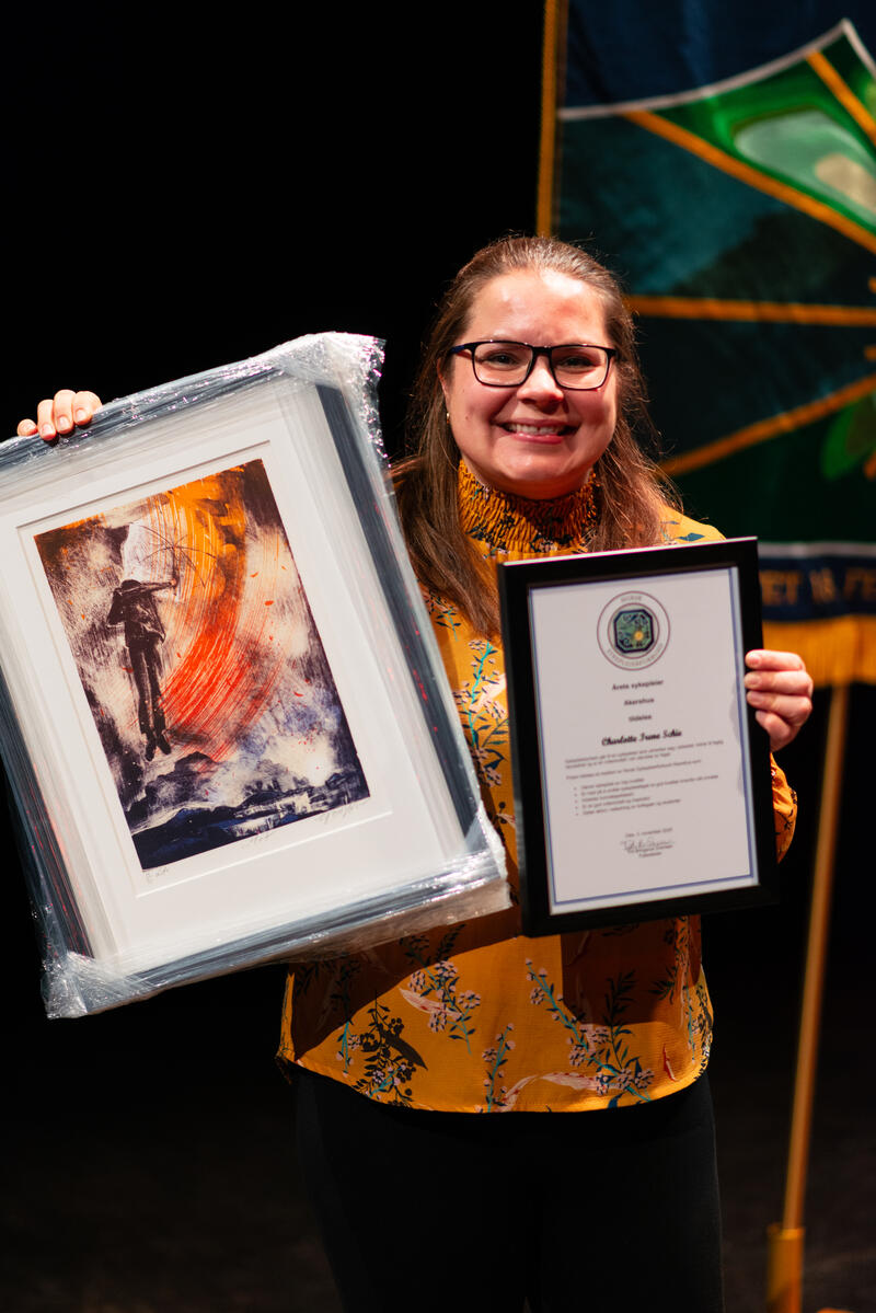 Charlotte Irene Schie med diplom og maleri