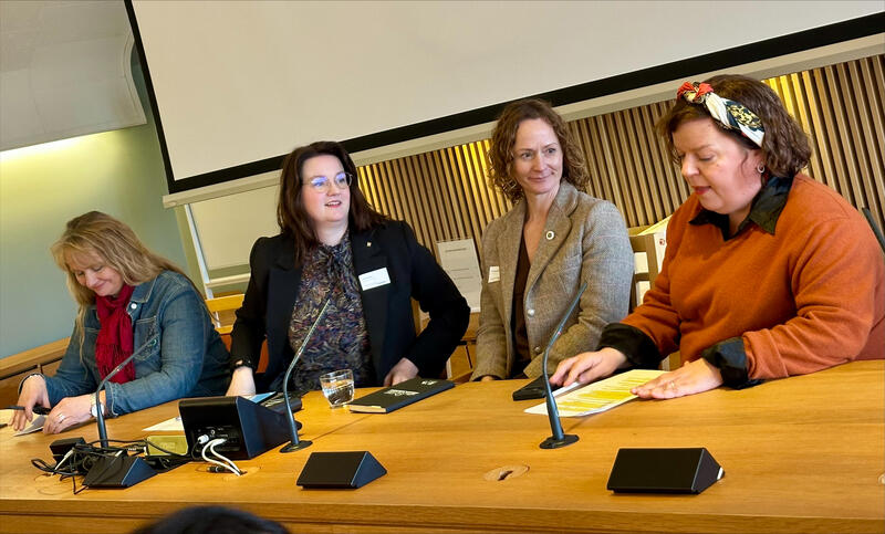 Tre kvinner sitter ved et bord.